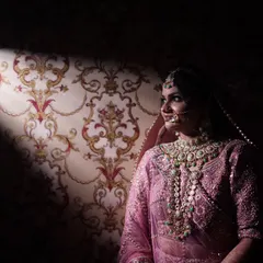 Using a single beam of light, I created this dramatic portrait. It highlights the bride in her beautiful pink lehenga against a dark, patterned background, creating a sense of mystery and elegance.