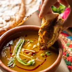 The perfect dipping shot. Capturing a piece of naan being dipped into a rich curry for Bawri India creates a highly engaging and satisfying image that makes you want to reach in and have a bite.