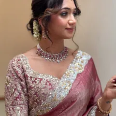 For me, modern elegance is about clean lines and a soft glow. I created this look for Monica's reception, focusing on a flawless base, defined eyes, and a romantic, messy hair bun that perfectly complemented her designer saree.