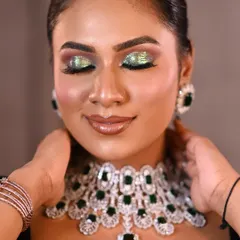 A vibrant and glamorous beauty shot designed to showcase a bold, glittery eye makeup look. The close-up framing allows every detail of the MUA's work to shine.