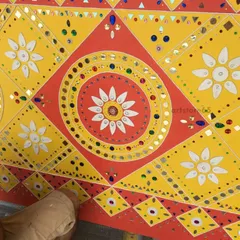 A close-up of a geometric pattern, showing the detailed mirror work within the floral and diamond shapes. This traditional style is known for its symmetry and sparkle, which we carefully recreate by hand.