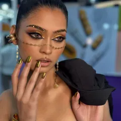 This is where makeup becomes art. A bold, editorial look I created for a show, featuring sharp graphic eyeliner, gold glitter accents, and matching metallic gold nails. This is the kind of advanced, creative work we explore in my professional course.