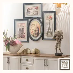 This gallery wall arrangement features a collection of memorabilia-style frames showcasing famous European landmarks. The mix of rectangular and oval frames creates a dynamic and visually interesting display.