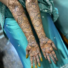 A wide shot displaying the full length of the bridal mehendi on both arms. This level of coverage is perfect for making a statement on your wedding or engagement day.