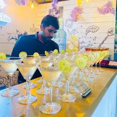 A tray of classic martinis, perfectly chilled and garnished with a lime wheel. We pride ourselves on our meticulous attention to detail, ensuring every drink is prepared and presented beautifully for your guests.