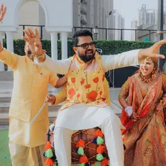 The groom getting into the spirit of the celebration, sitting on a dhol. It's all about capturing the fun, energy, and unforgettable moments of the wedding festivities.