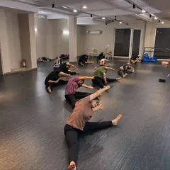 Our adult students work on their seated side stretches. Flexibility is a journey, and we focus on consistent, safe practice to achieve long-term results.