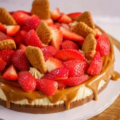 This strawberry and Biscoff cheesecake is a visual treat. The composition draws your eye to the generous toppings and the caramel drip. It’s a perfect shot for a bakery's menu or Instagram feed, promising a rich and fruity dessert experience.