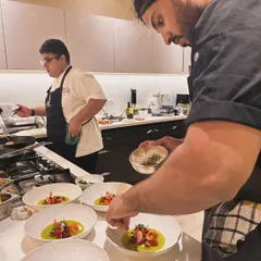 Plating a vibrant tomato and crab dish in a client's home. My team and I bring all the necessary equipment to execute a high-level menu anywhere.