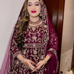 A beautiful bride in a deep wine-colored velvet outfit. The classic red lip and soft curls complete this elegant and royal look.