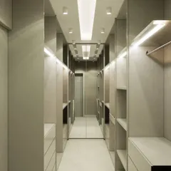 A luxurious walk-in closet we designed, featuring ample shelving, drawers, and hanging space. The mirrored back wall and integrated lighting create a high-end, boutique-like experience.