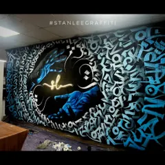 This is my signature calligraffiti style. For this showroom, I blended abstract calligraphy with realistic elements, creating a dynamic piece that wraps around the room. The glowing hands and custom lettering make it a one-of-a-kind installation.