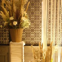 Another detail shot of our pampas grass arrangements. Placed on white pedestals against a decorative screen, these pieces add texture and height to the overall event design.