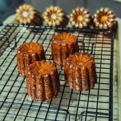 Freshly baked Canelé de Bourdeaux, a classic French pastry with a rich, custardy interior and a thick, caramelized crust.