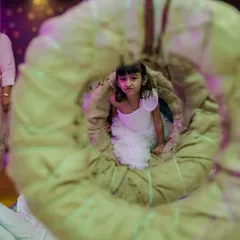 A creative shot through a tire swing, capturing a guest enjoying the indoor obstacle course. It's all about creating fun and playful moments.