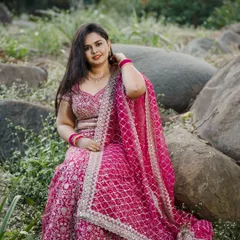 Dr. Meghana's ring ceremony look, captured outdoors. Her pink lehenga is paired with natural-looking makeup that enhances her features and looks beautiful in daylight.