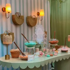 The full bath salt bar, elegantly styled with apothecary jars, fresh flowers, and custom signage, fitting seamlessly into the chic Parisian theme.