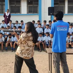 A coach demonstrating the correct shooting stance to students during a free workshop. This hands-on instruction is key to giving them a proper and safe introduction to the sport.