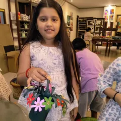 A student proudly holds the paper flower basket she made as a gift for Mother's Day. These handmade gifts are always filled with so much love.