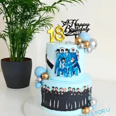 A two-tier cake for a K-Pop fan, celebrating the bands Enhypen and Seventeen. The cake is decorated with edible images of the band members and stylish balloon accents.
