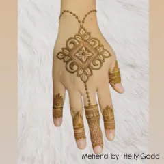 This design features a central geometric motif connected by a delicate chain to the finger. It's a modern, jewelry-inspired look that is both elegant and minimalist.