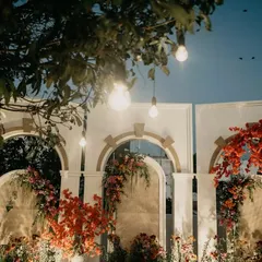 As dusk settled, the ceremony space took on a magical glow. The hanging bulbs and warm floral tones created an incredibly romantic setting for the evening pheras.