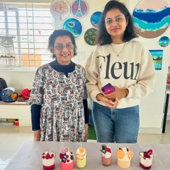 A mother and daughter proudly display the beautiful dessert candles they created together.