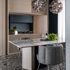 This six-seater dining table in the 'Wedged Haus' is accommodated in an arm alongside the kitchen entrance. The light oak of the kitchen's monolithic block provides a warm backdrop, while the marble tabletop and sculptural chairs define the dining zone.