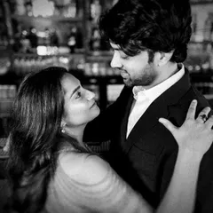 An intimate black and white close-up taken during a bar photoshoot. The low light and intense gaze between the couple create a moody and romantic atmosphere.