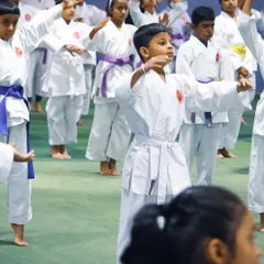 Young students in white and purple belts practice their stances during a group training session before their grading exam. We focus on perfecting the basics to build a strong foundation.