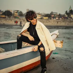 An edgy men's fashion shoot on the beach, using a boat as a prop. This combines a rugged location with a stylish look for a unique portfolio image.