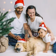The whole family, including a very patient golden retriever, in Santa hats. Capturing everyone you love in one frame is what makes a holiday photo truly complete.