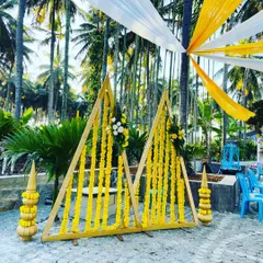 For this haldi setup, I used modern triangular wooden frames decorated with strings of yellow marigolds. This design combines contemporary geometric shapes with traditional flowers for a unique look.