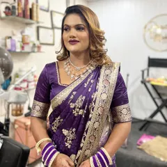 A beautiful client ready for a party. Her hair is styled with soft, glamorous waves and highlights, a perfect look for a modern saree.