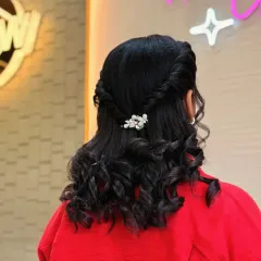 A simple yet elegant hairstyle with twisted-back sides and soft curls. The pearl barrette adds a touch of class to this look, perfect for any occasion.
