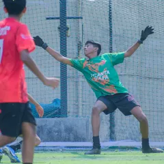 A goalkeeper making a full-stretch save during a match. Our training prepares them for crucial, game-defining moments like this.