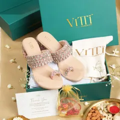 A festive flat lay for a Rakshabandhan campaign, featuring embellished sandals in a gift box. The styling includes a rakhi and traditional thali to create a complete festive story.