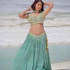 A stunning shot of our light green sequin lehenga against a snowy backdrop. This outfit is perfect for a unique pre-wedding or fashion photoshoot.