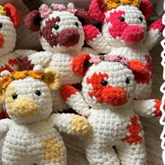 A whole herd of our chunky yarn crochet cows, ready to find new homes. Each one features unique patches and a tiny floral crown, making them irresistibly cute.
