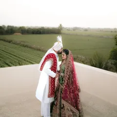 A tender moment between the bride and groom on a rooftop overlooking lush green fields. A perfect blend of intimacy and a beautiful destination wedding landscape.