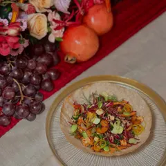 The first course of an Asian-inspired dinner: a chopped crunchy salad with cilantro lime dressing and sriracha cashews, served in a tortilla bowl for a delightful texture.