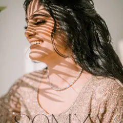 A creative bridal portrait using the shadow of a palm leaf to create a beautiful pattern of light on her smiling face.