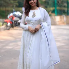A vision in white. I designed this elegant white Anarkali with a delicate, hand-embroidered motif on the neckline. It's a timeless and graceful outfit, perfect for a special occasion.