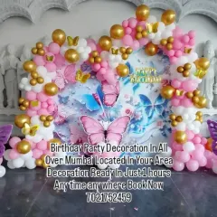 A lovely butterfly garden theme with a printed backdrop and matching balloon pillars. The pink, white, and gold balloons create a soft and pretty look for the celebration.