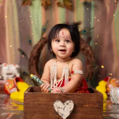 Peek-a-boo! A playful moment with our little Krishna popping out of a wooden box.