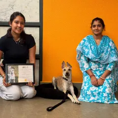 Posing proudly with Mooli and her family. The handler transfer sessions ensure they have the tools to continue her success at home.