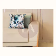 A close-up of a custom sofa, showing the clean lines and the beautiful floral cushion that adds a pop of color and pattern. Every detail is curated to reflect the client's story.
