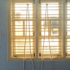 You don't always need a full studio. Here is a simple rope setup on a window, showing how therapeutic yoga can be adapted for your own home practice to maintain consistency in your healing journey.