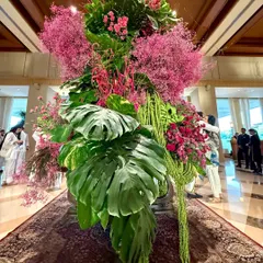 Another view of this tropical pink arrangement, showing how the composition brings a burst of life and color to the grand hotel lobby, welcoming guests with natural beauty.