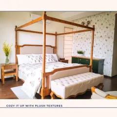 A classic four-poster bed brings a touch of timeless elegance to this bedroom. Paired with a delicate botanical wallpaper and a plush bench, this space is designed to be a cozy and luxurious retreat.